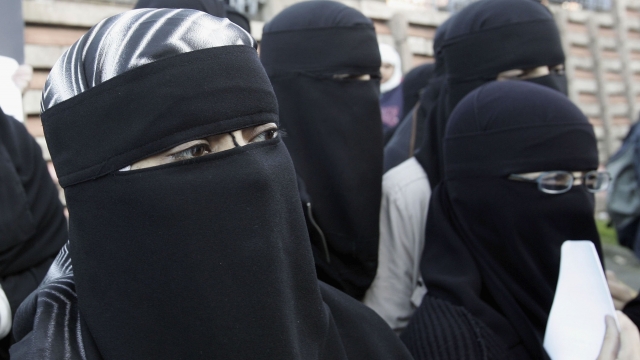 Muslim women wearing niqabs veil protest outside Bangor Street Community centre.