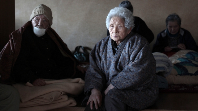 Elderly Japanese sitting in a room.