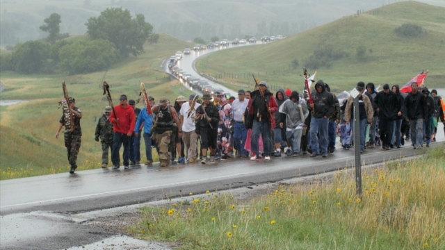 A group of American Indians walk to a Dakota Access Pipeline construction site to protest.