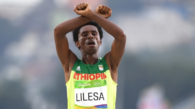 Feyisa Lilesa of Ethiopia celebrates as he crosses the line to win silver during the Men's Marathon.
