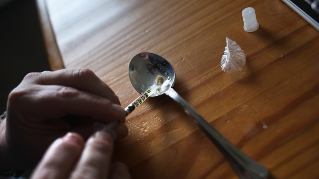 A heroin user prepares an injection.