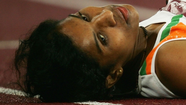 OP Jaisha of India lays on the track after finishing third in the Women's 5000m during the 15th Asian Games Doha 2006.