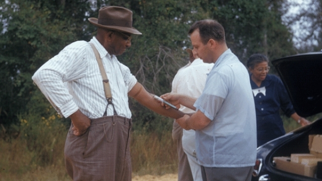 A researcher draws blood from a Tuskegee Syphilis Study subject.