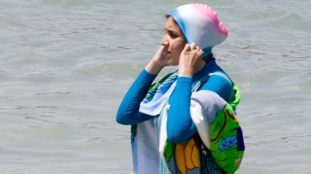 A girl wearing a fashionable burqini on the beach of Alexandria, Egypt