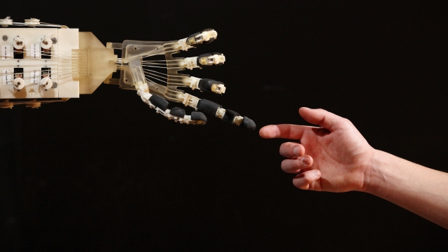 A human touching a robot.