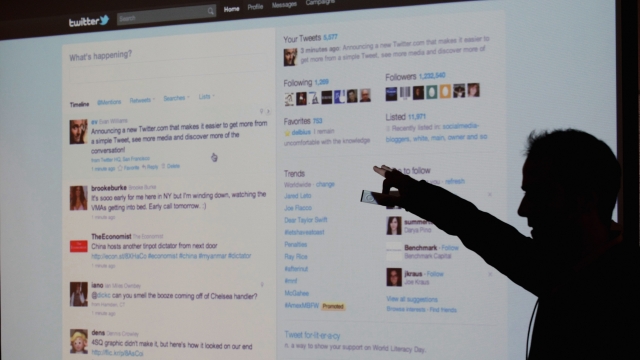 Former Twitter CEO Evan Williams is seen silhouetted against a screen as he shows off Twitter's website.