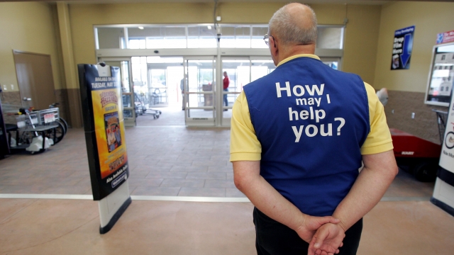 A Wal-Mart greeter waits to welcome new customers to a Walmart store in Bowling Green, Ohio.