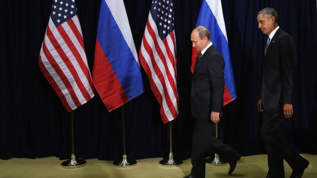 Russian President Vladimir Putin and U.S. President Barack Obama walk out on a stage with U.S. and Russian flags