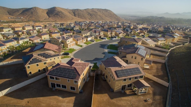 Solar panels are installed on many homes in a neighborhood.