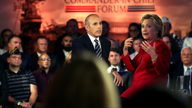 Matt Lauer looks on as Democratic presidential nominee Hillary Clinton speaks during the NBC News Commander-in-Chief Forum.