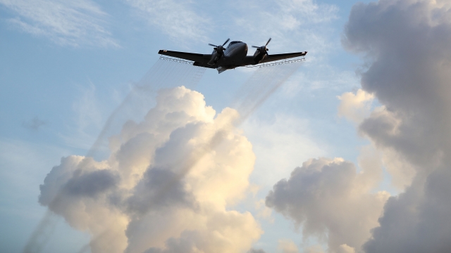 A plane sprays pesticide over the Wynwood neighborhood in Miami to control and reduce the number of mosquitos.