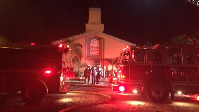 Emergency responders stand outside the Islamic Center of Fort Pierce after it was set on fire.