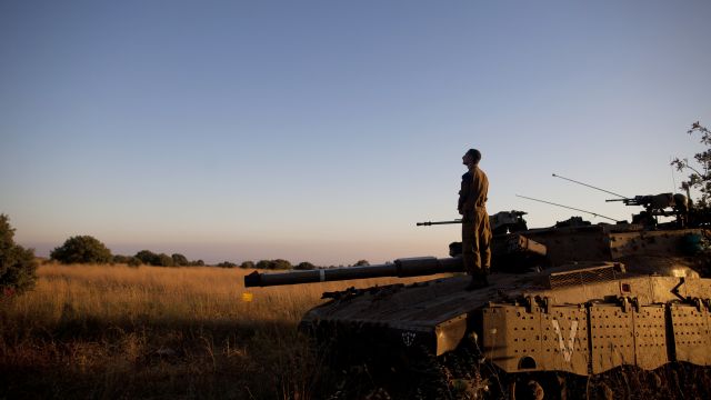 An Israeli soldier prays on a Merkava tank on the Israeli-Syrian border near Quneitra on June 22, 2014.