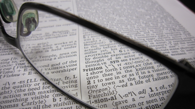 A pair of glasses on top of a dictionary.