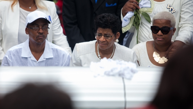 The mother of Sandra Bland, Geneva Reed-Veal, center, and sister Shavon Bland, right, mourn at the grave site.