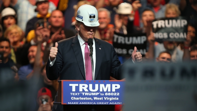 Republican Presidential candidate Donald Trump models a hard hat in support of the miners.