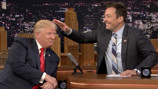 Jimmy Fallon reaches out to touch Donald Trump's hair.