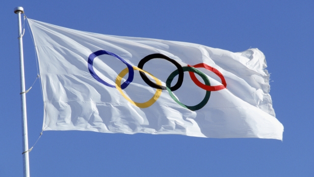 The Olympic flag flies.
