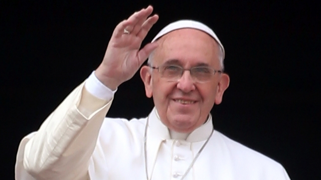 Pope Francis waves to the faithful as he delivers his Christmas Day message.