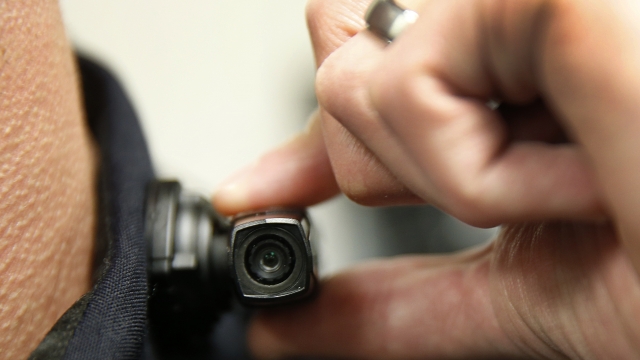 A West Valley City police officer shows off a newly deployed body camera attached to his shirt collar in 2015 in Utah.