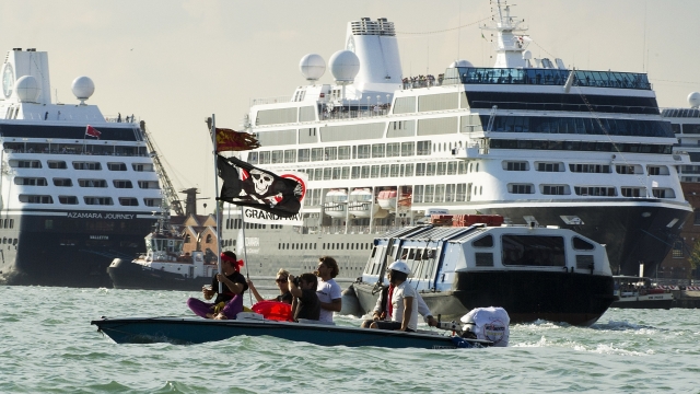Protesters use a boat in the Giudecca Canal to block cruise ships inside the port.