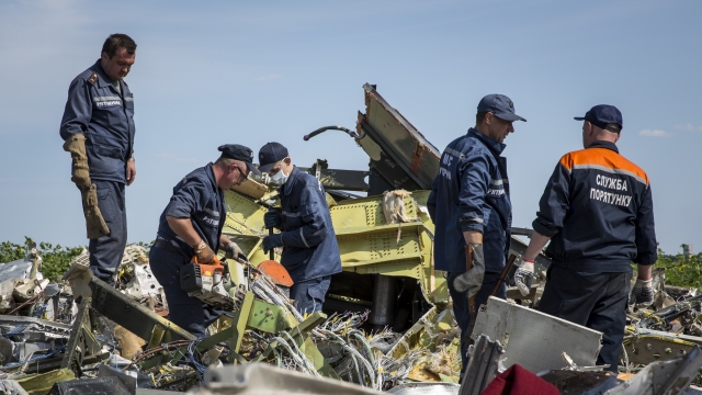 Ukrainian officials inspect wreckage thought to be from Malaysia Airlines Flight 17.