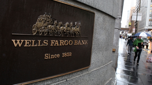 Pedestrians walk by a Wells Fargo Bank branch office.