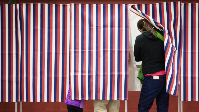A woman votes at a booth.