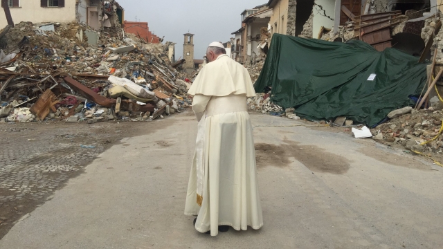 Pope Francis prays silently among the rubble in Amatrice, Italy.