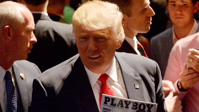 Donald Trump shows a police officer his photo on the cover of a Playboy magazine.