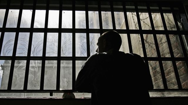 A 19-year-old inmate looks out a prison window.