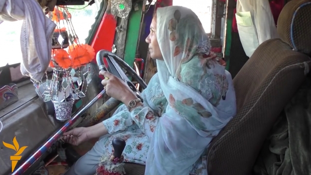 Pakistan's first female truck driver in the cab of her truck