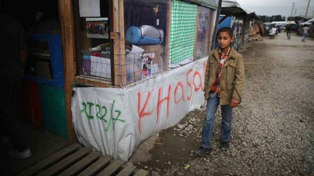 A young boy walks past the Jungle Books Cafe in the Jungle migrant camp on September 6, 2016 in Calais, France.