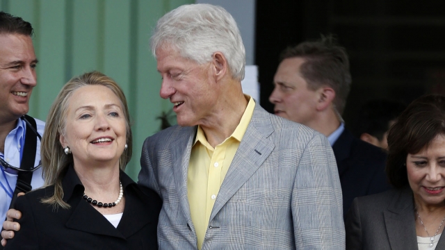 Bill Clinton puts his arm around Hillary Clinton's shoulders.