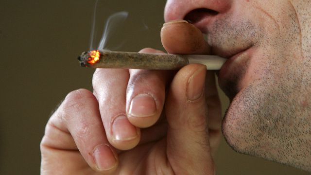 A man smokes a marijuana joint.