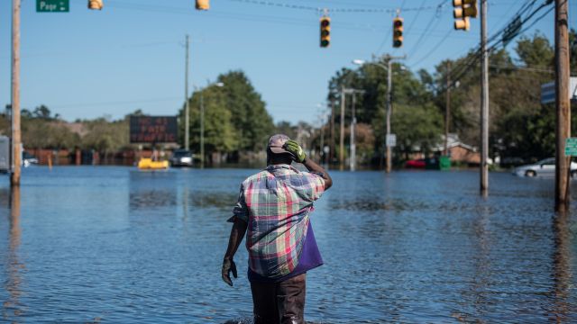 A man walks down a flooded street in North Carolina.