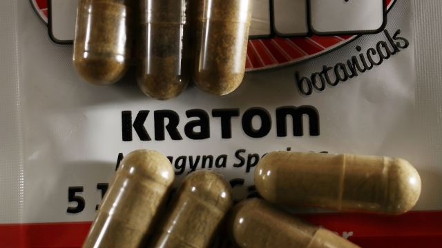Kratom pills lay on packaging.
