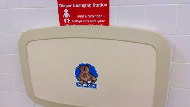 A diaper changing table inside a public restroom.