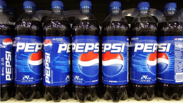 Bottles of Pepsi are displayed on a store shelf.