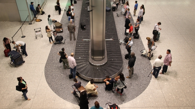 Passengers wait in the baggage hall at terminal five at Heathrow airport in London.