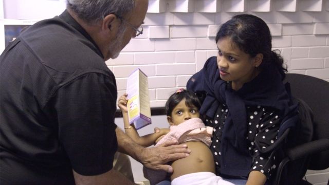 Paul Caulford examines Anushka. Anushka, 2, and her mother just arrived to Canada from India.