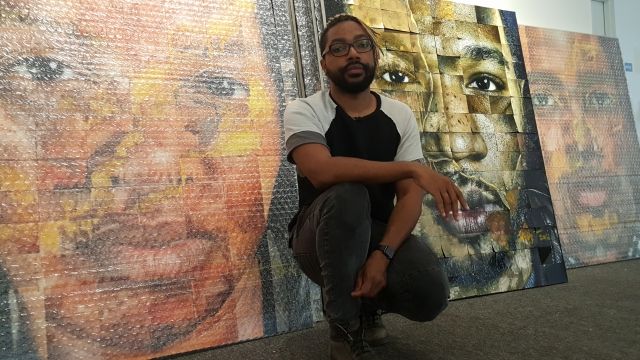 Chicago artist Ervin A. Johnson in front of his portraits