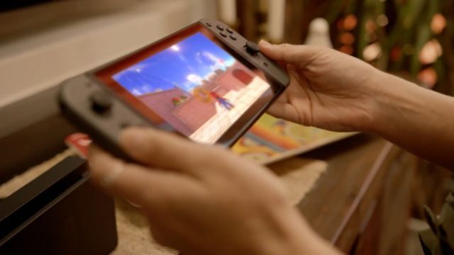 Hands hold the portable iteration of the Nintendo Switch system.