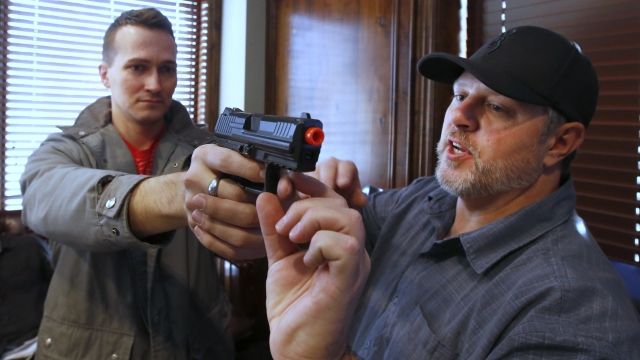 A man is shown how to hold a gun in a concealed carry permit class.