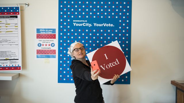 Woman poses with a massive "I voted" sticker.