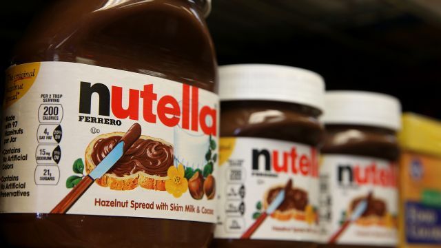Jars of Nutella are displayed on a shelf at a market.