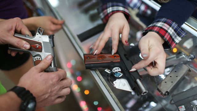 Hands touching guns at a counter