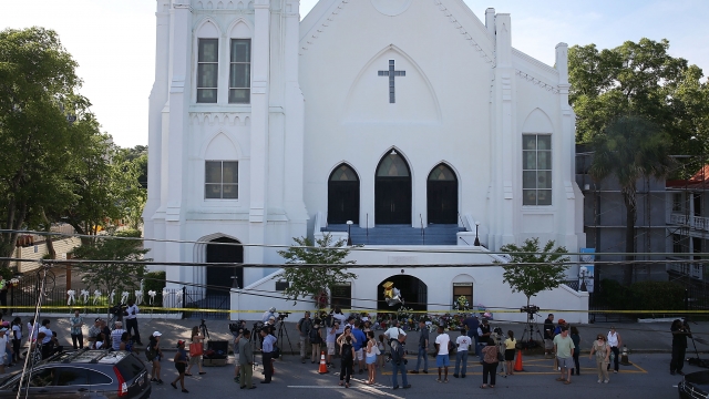 People stand outside the Emanuel AME Church after a mass shooting.