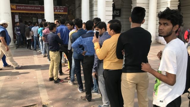 People line up outside a bank in India