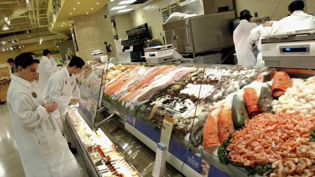 Shoppers at the seafood section of a grocery store.